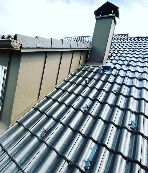Modernes Blechdach mit Schornstein auf Wohnhaus